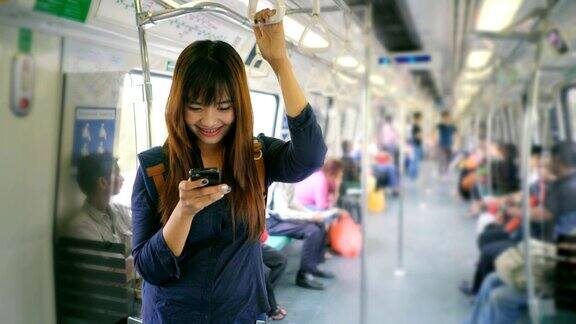年轻女子在火车上使用智能手机