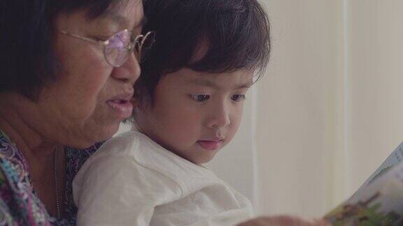 亚洲小男孩和爷爷奶奶在床上看书