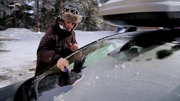 年轻人正在清理雪地里的汽车