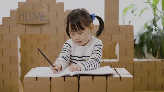 蹒跚学步的女孩练习书写字母在家上学