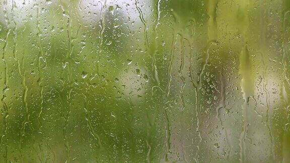 窗外的雨和雨滴顺着玻璃流下来