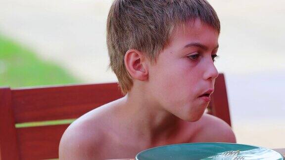 孩子在外面吃饼干憨厚帅气的金发小男孩在吃甜