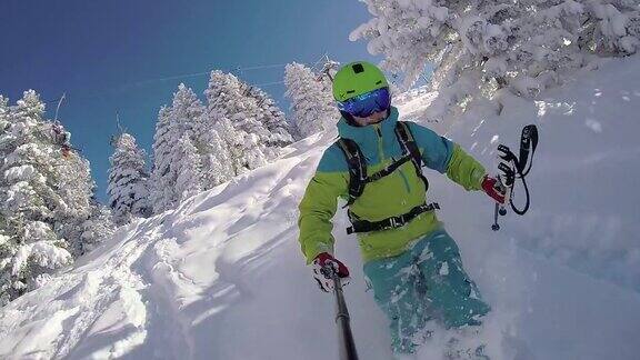 慢动作:极限自由式滑雪者在阳光明媚的山上骑着新鲜的粉末雪