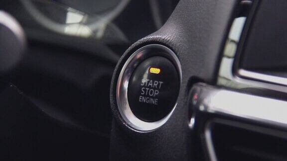 启动汽车引擎追踪到按钮用手指按下按钮启动汽车引擎