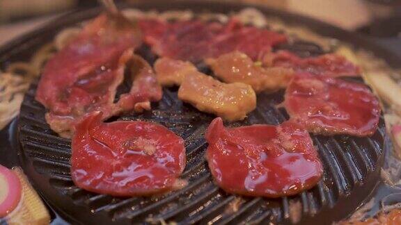 烹饪烧烤在炉子上的木炭上烤关闭牛肉烤在日本餐厅用于烧烤或日式食物的生牛肉片