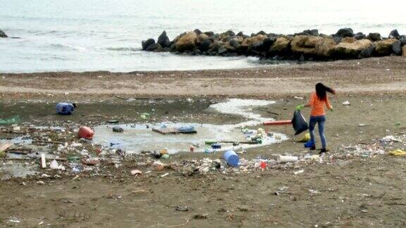 年轻女子清理肮脏的海滩生态灾难