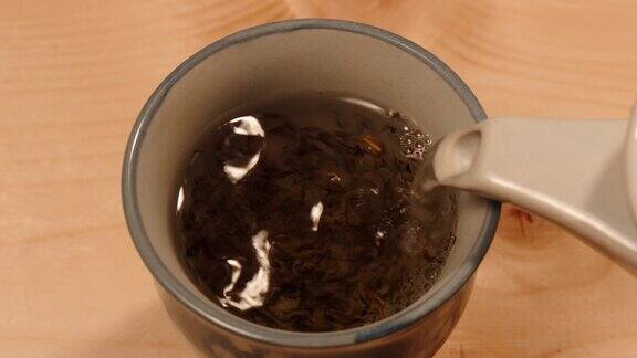 将热水倒入一杯绿茶中