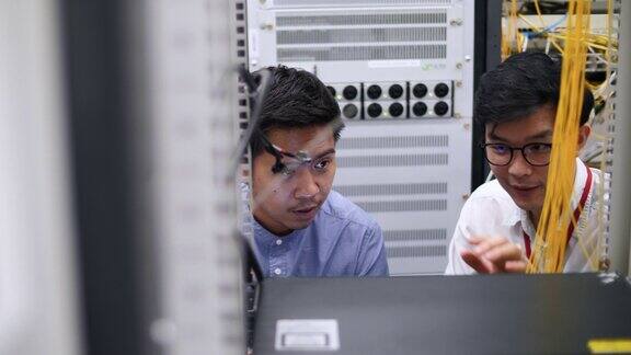 两名IT技术人员站在工作数据中心