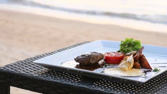 烤菲力牛排在度假餐厅海滩桌子上的海上