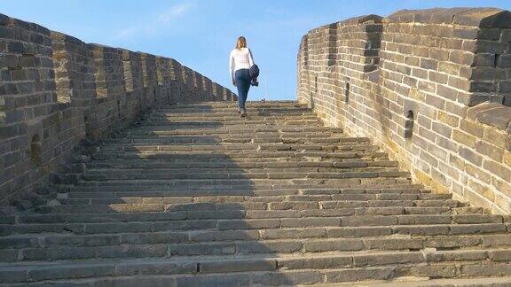 低角度:一名女子走上长城顶上的一段楼梯
