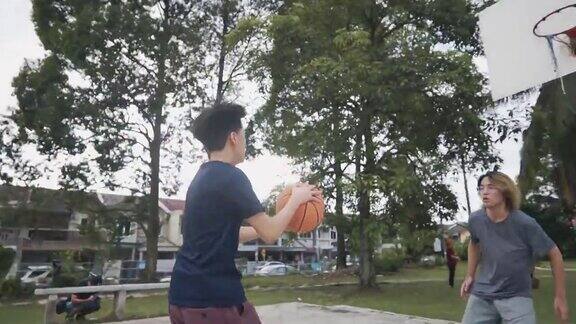 慢动作一对一Z一代亚裔中国少年在周末早上和朋友练习篮球比赛时与对手决斗挑战和投篮