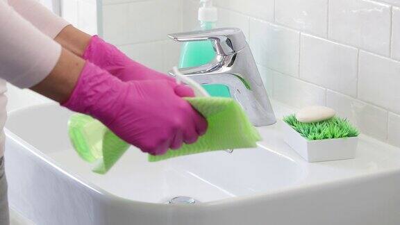 喷洒消毒剂用抹布擦洗浴室水槽