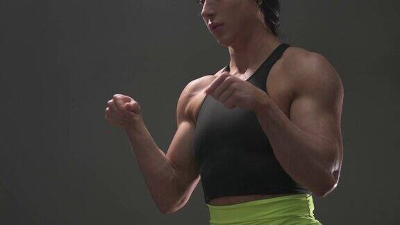 肌肉发达的女性健美女性在健身房锻炼手臂:二头肌和三头肌运动和保健概念