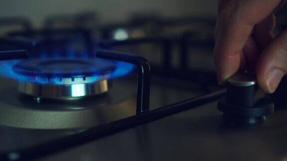 厨房煤气灶起火蓝色火焰由妇女手关闭