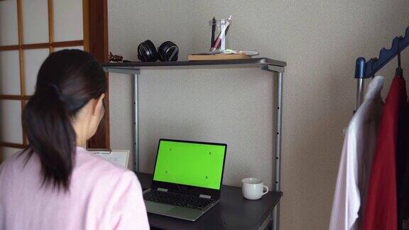 女人在家里开视频会议用笔记本电脑的彩色键屏