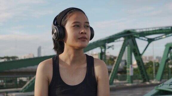 亚洲女运动员通过耳机听音乐