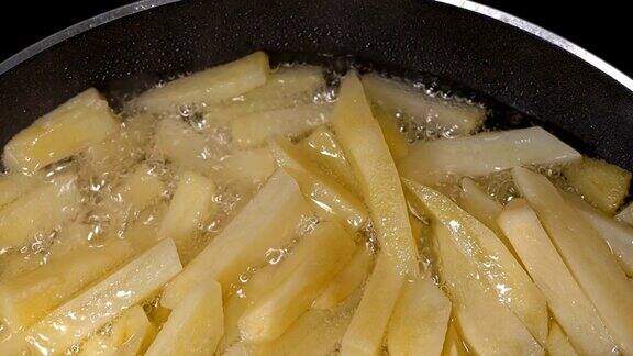 在平底锅里炸土豆片特写