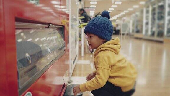 亚洲小男孩正在往自动贩卖机里捡水瓶