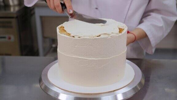 糕点师用金属刮刀将蛋糕顶部与奶油对齐