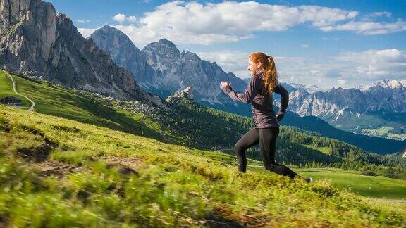 一个女人在草地上奔跑背景是群山