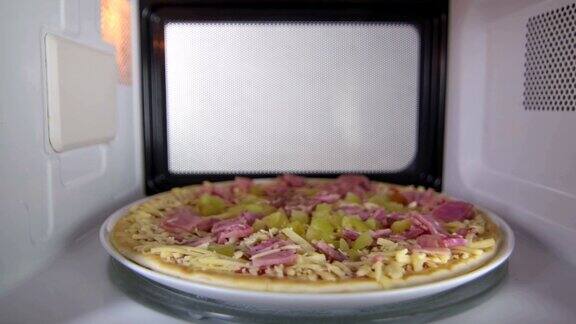 冷冻生火腿披萨在微波炉内解冻