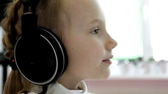 一个小女孩正戴着耳机听音乐