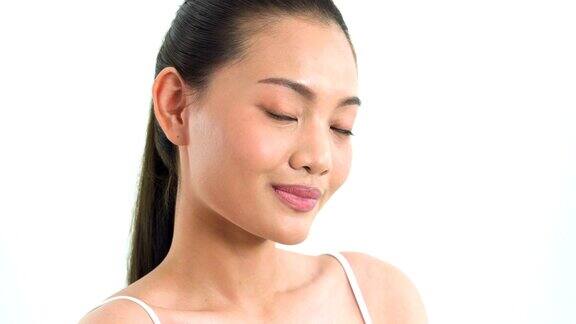 头部拍摄视图:亚洲美女使用腮红刷在白色背景上的脸颊人以美容、保健、情感为理念
