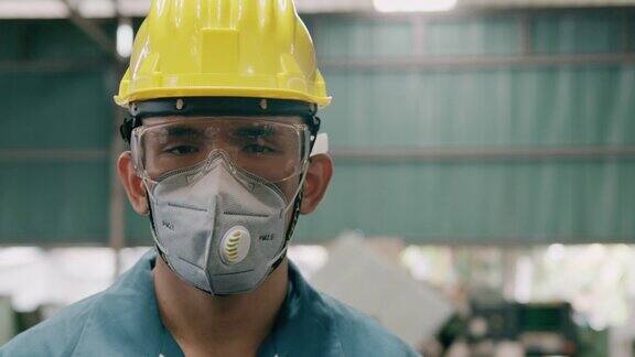 自信的年轻产业工人肖像戴着面具近距离慢动作亚裔男性工作服头盔工业和制造业概念