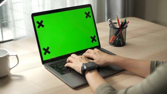 俯视图男性的手工作在笔记本电脑与绿色屏幕