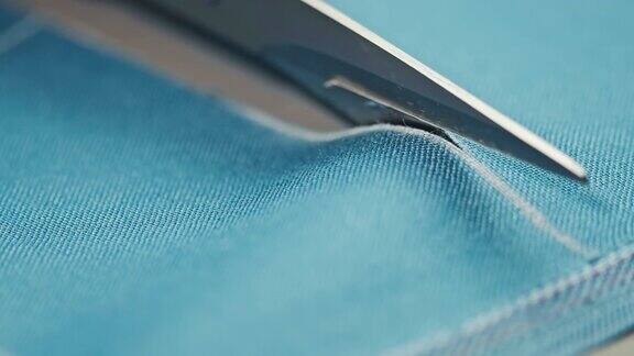 裁缝用剪刀沿着图案线把布料剪下来在家缝衣服