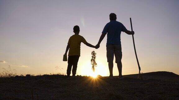 种完树后父子俩在一起看日落