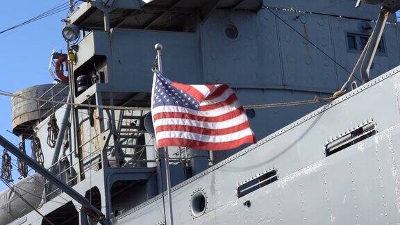美国国旗在一艘军舰前迎风飘扬慢镜头