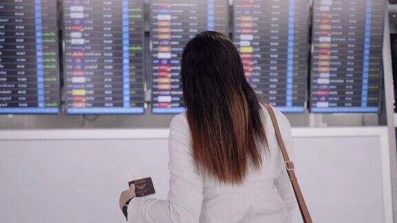 机场女商人亚洲女商人用行李、背包和笔记本电脑在屏幕上检查她的商务旅行的航班时间头部照片