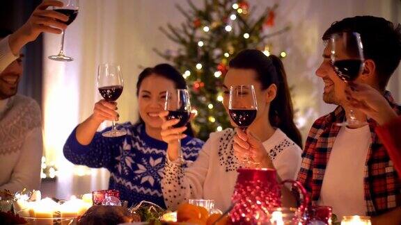 快乐的朋友在圣诞晚宴上喝红酒慢镜头