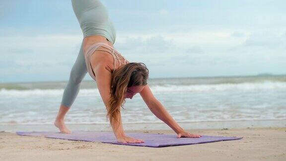 运动女子瑜伽姿势在沙滩上练习瑜伽冥想