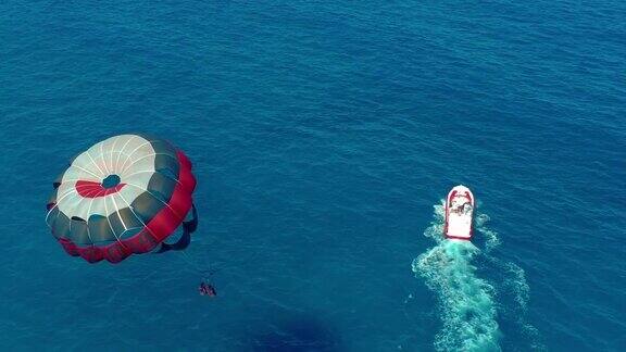 鸟瞰图在船后面用降落伞飞行海上极限水上运动帆伞运动