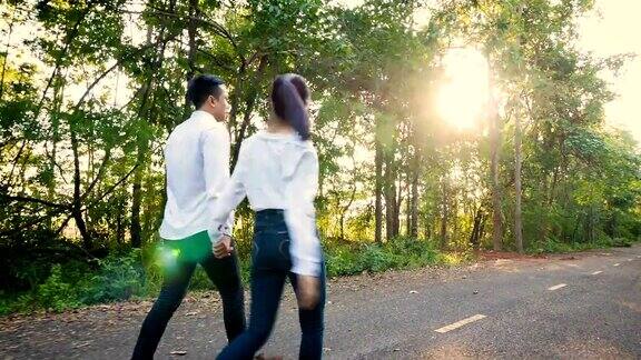 相爱的年轻夫妇喜欢在户外公园散步手牵着手