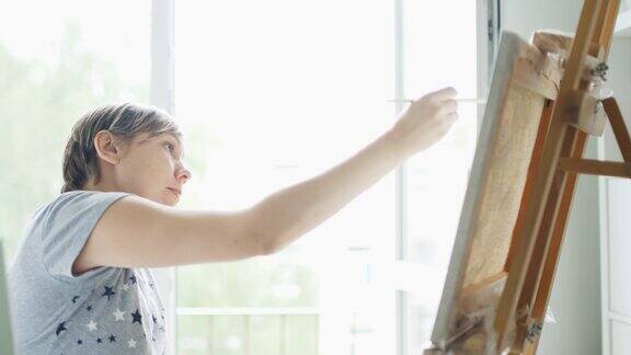 女艺术家在家庭工作室的画布上画画