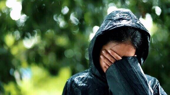 年轻女子在雨中穿着雨衣