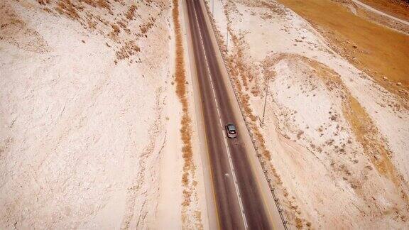 汽车行驶在直线公路上的沙漠鸟瞰图