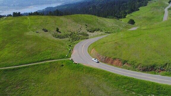 鸟瞰图的汽车驾驶下的乡村道路通过农村起伏的山