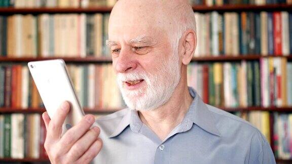 现代老年人在家通过短信应用打电话书柜书架在背景