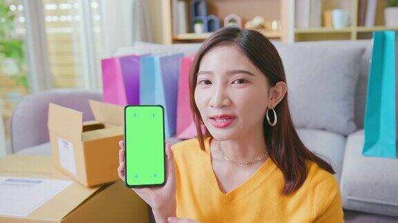 女子展示绿色屏幕手机