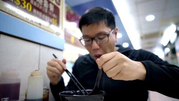 一名亚洲男子在餐厅吃香港汤面