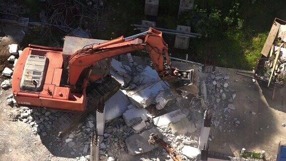 挖掘机正在破坏一堵混凝土墙