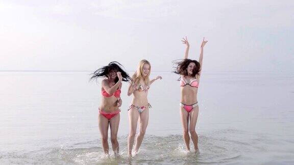 三名少女在沙滩上跳舞的日落慢动作