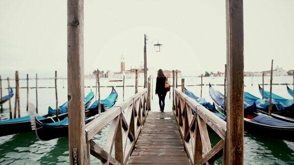 走在意大利威尼斯大运河码头上的女人