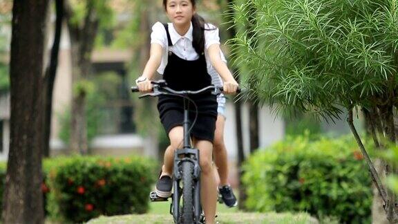 亚洲青少年在公园里骑自行车