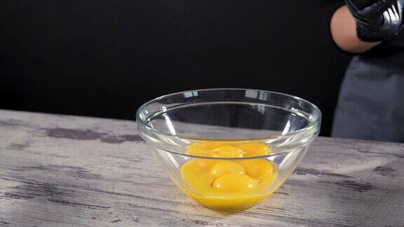 新鲜的鸡蛋掉进碗里蛋黄落在玻璃碗里把蛋黄和蛋白质分开