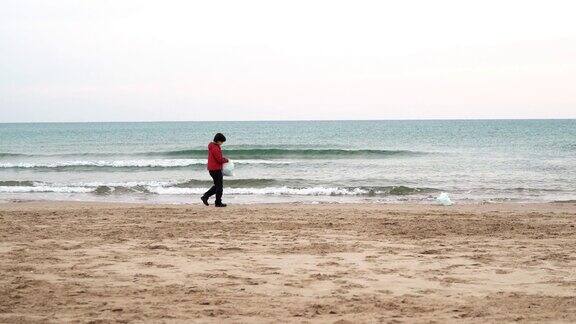 新冠肺炎疫情期间一名志愿者在海滩捡拾塑料垃圾海洋污染